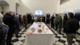 Photo de nombreuses personnes autour d'une table sur laquelle sont posées des viennoiseries