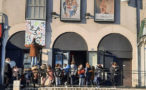 Photo des enfants devant le cinéma qui regardent leur affiche en train d'être posée