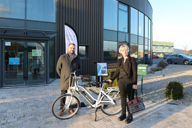 Photo de la gagnante avec le vélo aux côtés du vice-président au plan climat