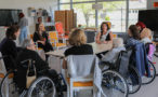 Photo d'un atelier théâtre à l'EHPAD du Grand Mont de Contres avec les artistes, des lycéennes et des résidentes de l'EHPAD assises autour d'une table