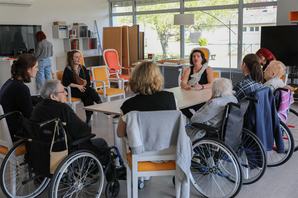 Photo d'un atelier théâtre à l'EHPAD du Grand Mont de Contres avec les artistes, des lycéennes et des résidentes de l'EHPAD assises autour d'une table