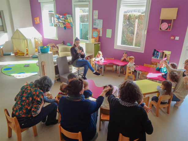 Photo des enfants et des professionnels de l'accueil individuel et collectif assis en ronde