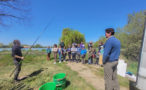 Photo de la sortie pêche de l'accueil de loisirs de Soings-en-Sologne où des enfants sont en train d'écouter un intervenant, une canne à pêche dans la main