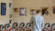 Photo d'un homme devant une exposition de peintures