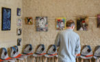 Photo d'un homme devant une exposition de peintures